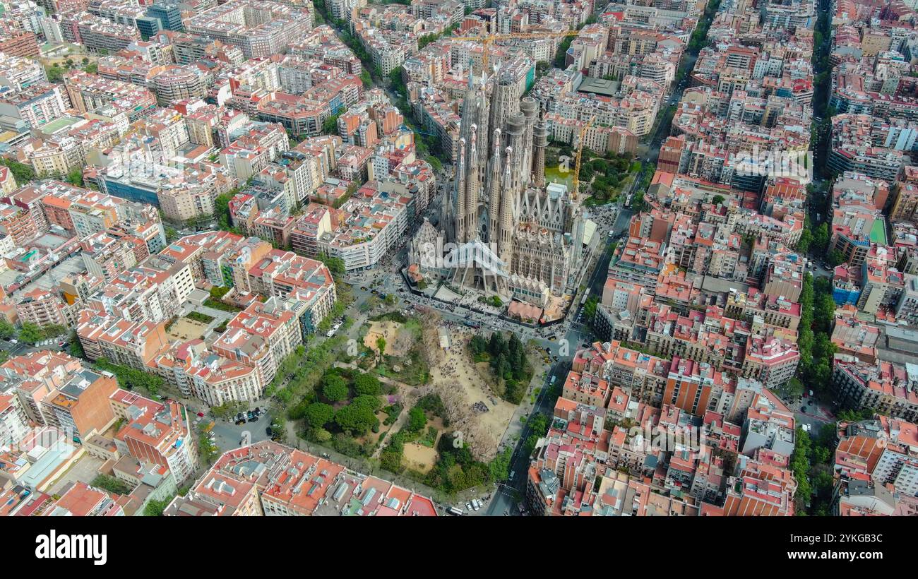 Blick aus der Vogelperspektive auf Barcelonas berühmte Sagrada Família, umgeben von dichten Stadtblöcken in pulsierender Stadtlandschaft. Stockfoto