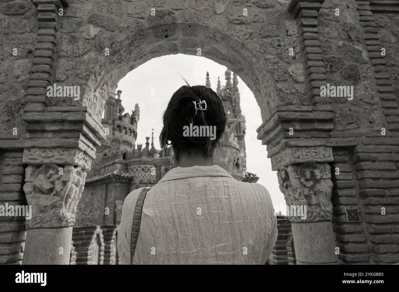 Ein Besucher, der die komplizierten Bögen und Türme der Burg Colomares in Schwarz-weiß-Szene bewundert Stockfoto