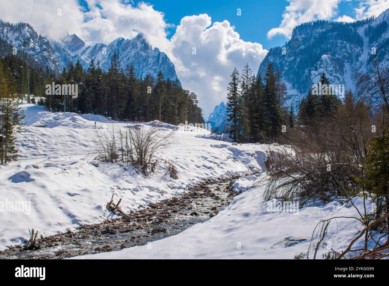 Der Bach fließt zwischen den Felsen im schneebedeckten Panorama der Dolomiten von Toblach, Italien Stockfoto