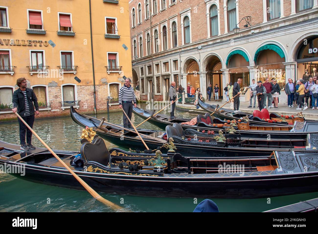 Venedig, Italien;17. Oktober 2024: An einem sonnigen Tag in Venedig navigieren Gondoliere fachmännisch durch die malerischen Kanäle der Stadt und zeigen eine Tradition Stockfoto