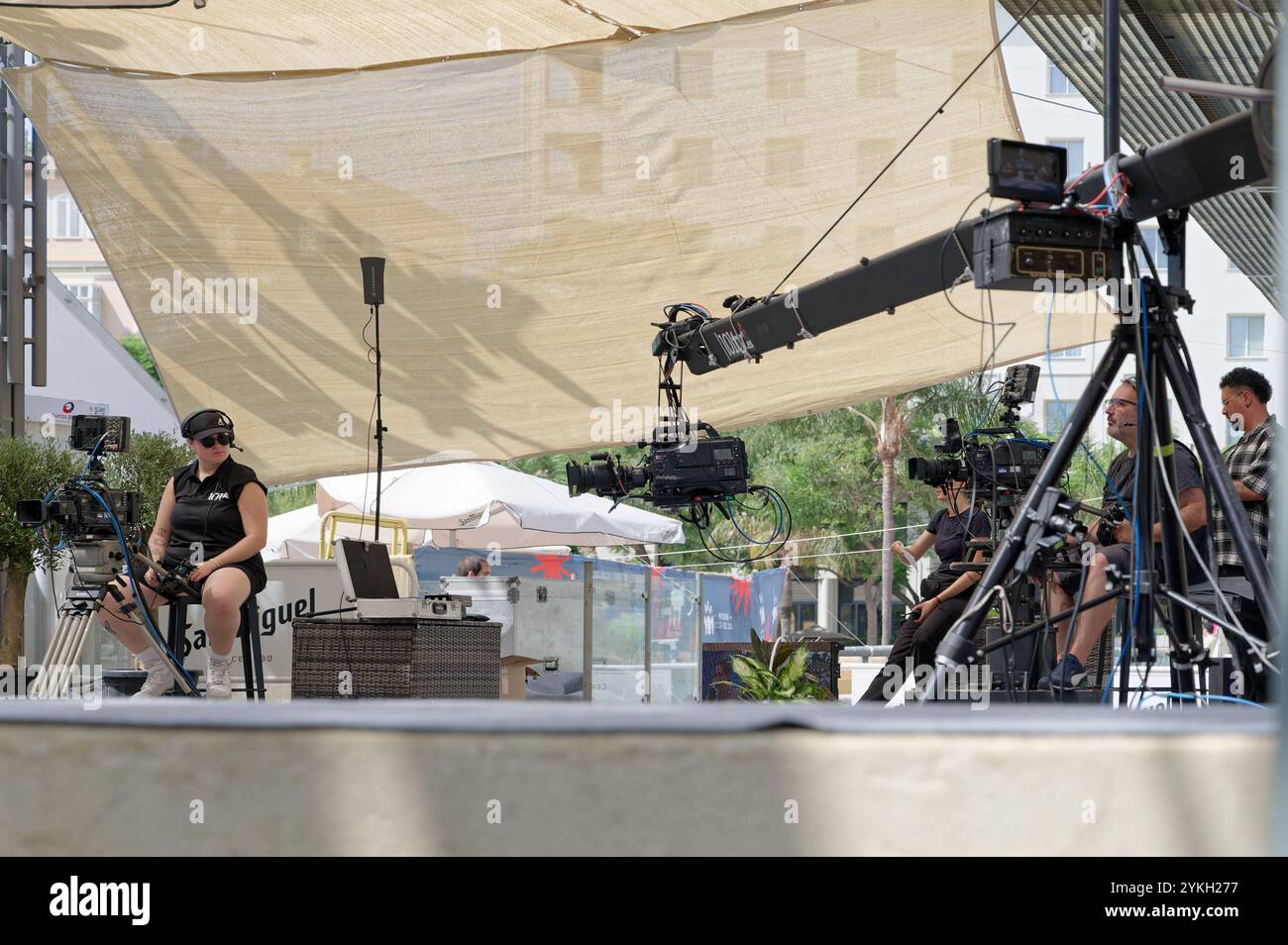 Filmcrew, die Kameras im Schatten während der Messe im august in Malaga aufstellte Stockfoto