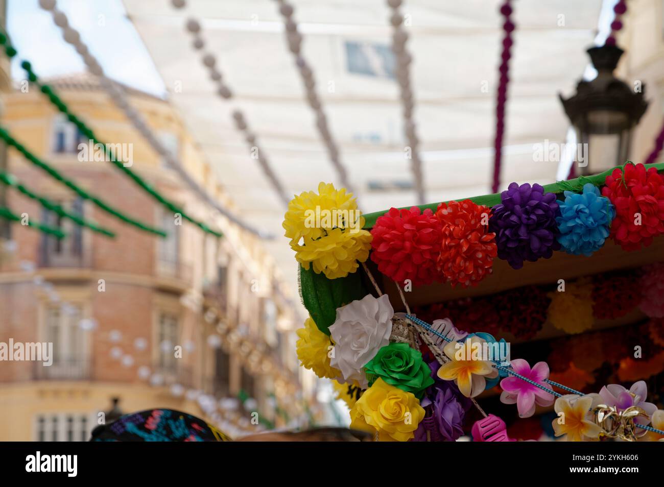 Farbenfrohe Papierblumen und farbenfrohe Dekorationen zieren die Calle Larios während der lebhaften Augustmesse Stockfoto