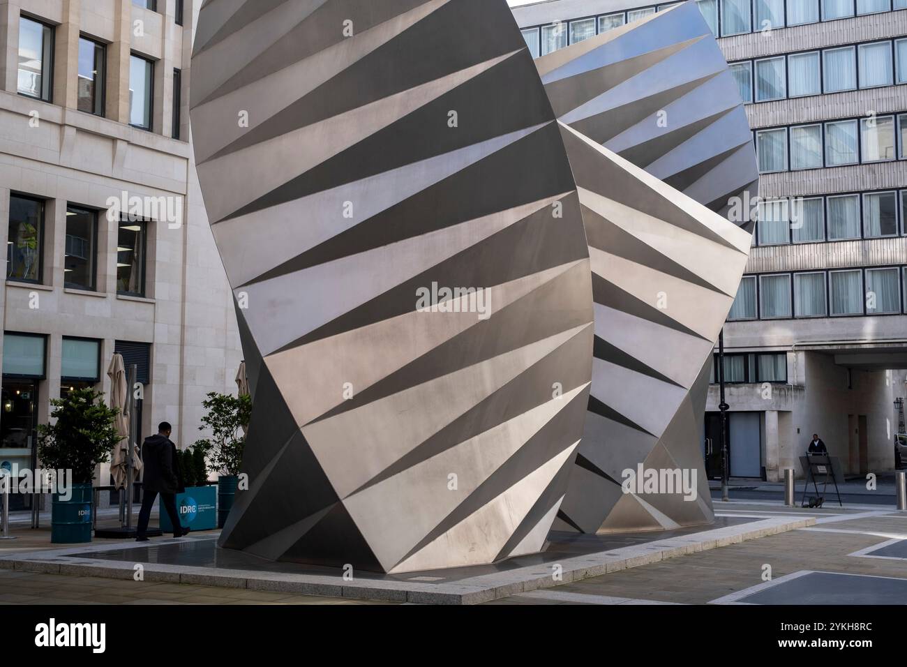 Am 8. Oktober 2024 in London, Großbritannien, spazieren die Menschen vorbei an Paternoster Vents, einer großen öffentlichen Skulptur am Paternoster Square in der City of London. Paternoster Vents, auch bekannt als Angels Wings des Künstlers Thomas Heatherwick, ist eine Skulptur aus Edelstahl aus dem Jahr 2002, die auf der Paternoster Lane installiert wurde. Die Skulptur dient der Belüftung einer unterirdischen elektrischen Unterstation. Stockfoto