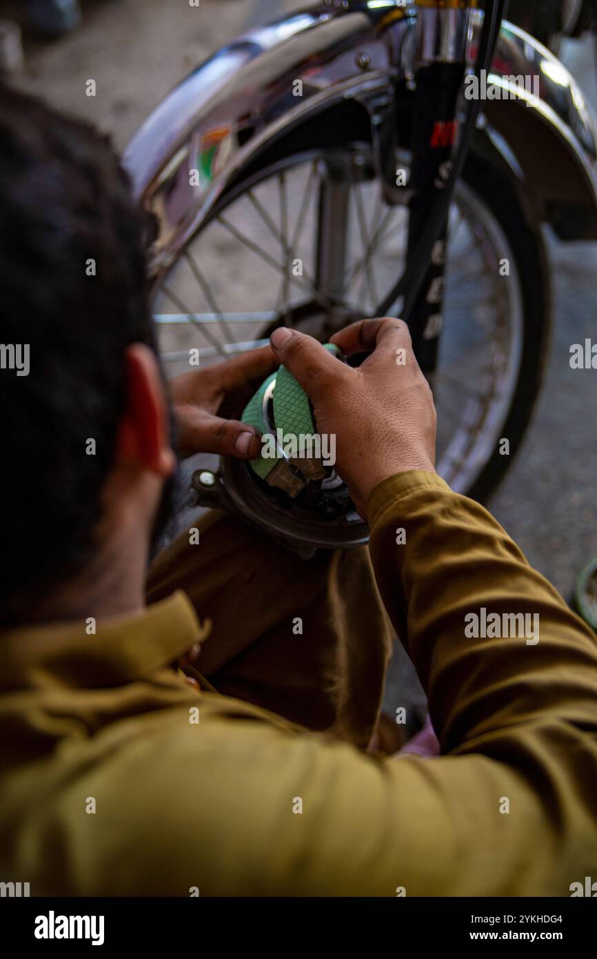 Nahaufnahmen einer Motorradwerkstatt im SWAT Valley, Pakistan, bei der Werkzeuge, Fahrräder und erfahrene Mechaniker bei der Arbeit erfasst werden۔ Stockfoto