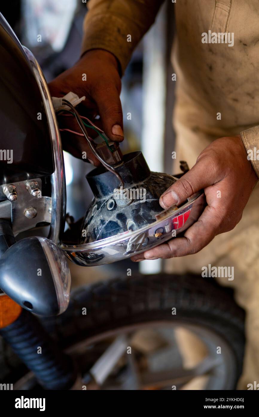 Nahaufnahmen einer Motorradwerkstatt im SWAT Valley, Pakistan, bei der Werkzeuge, Fahrräder und erfahrene Mechaniker bei der Arbeit erfasst werden۔ Stockfoto