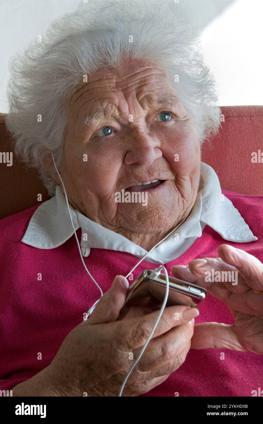 ÄLTERE DAME iPod MEDIEN AUDIO BUCH MUSIK PLAYER LERNEN SPRACHE OHRHÖRER ältere Dame mit ihrer neuen Technologie tragbare Player für eine Vielzahl von digitalen Audio-Medien-Dateien Stockfoto