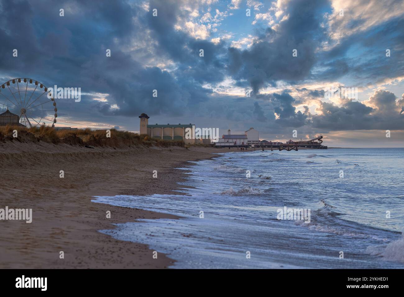 Strandlandschaft mit Riesenrad und dramatischem Himmel. Stockfoto