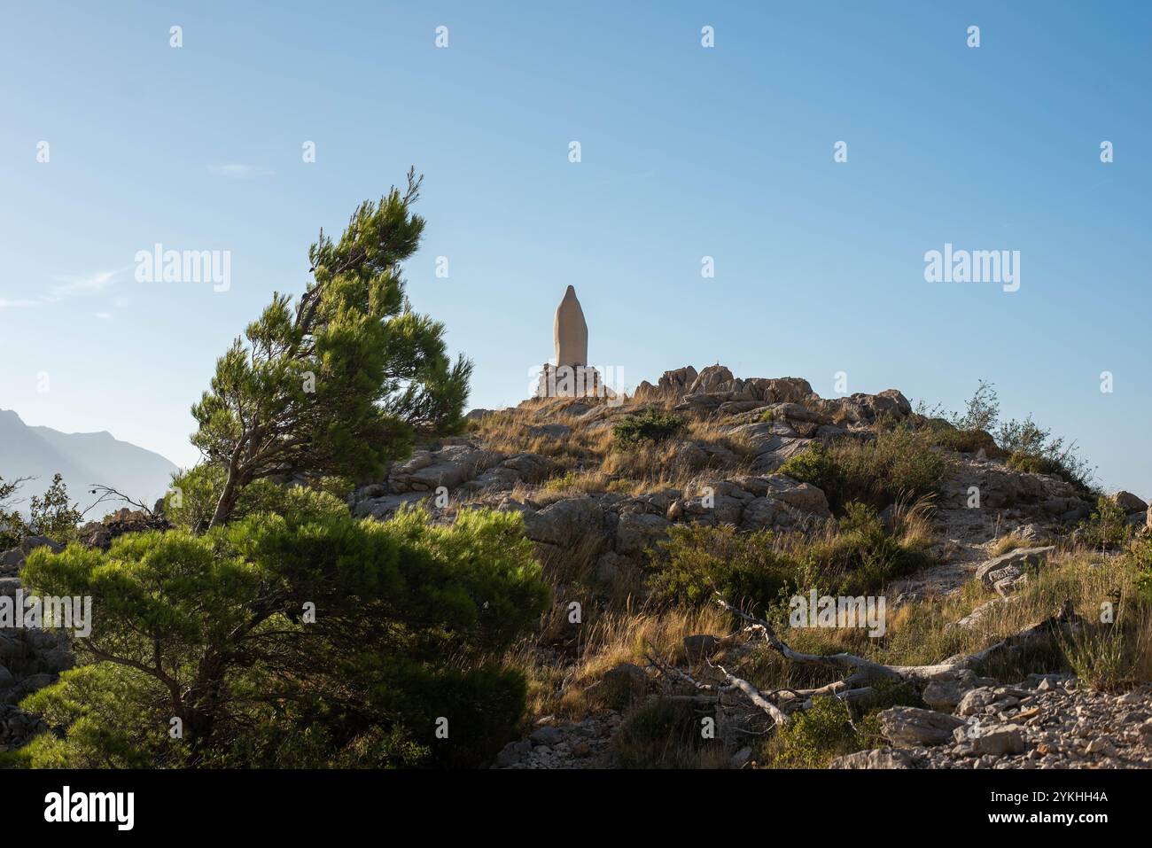 Statue der Jungfrau Maria in den kroatischen Bergen, mit einer Gebetstafel „Heil Maria“ umgeben von der Natur. Stockfoto