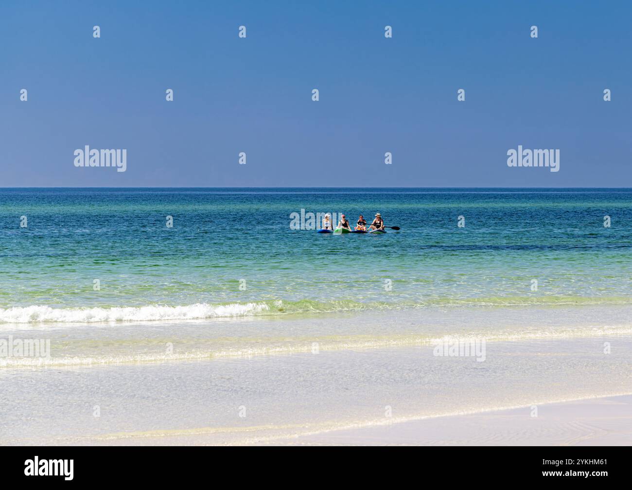 Vier Frauen auf Paddelbrettern genießen das Wasser Stockfoto