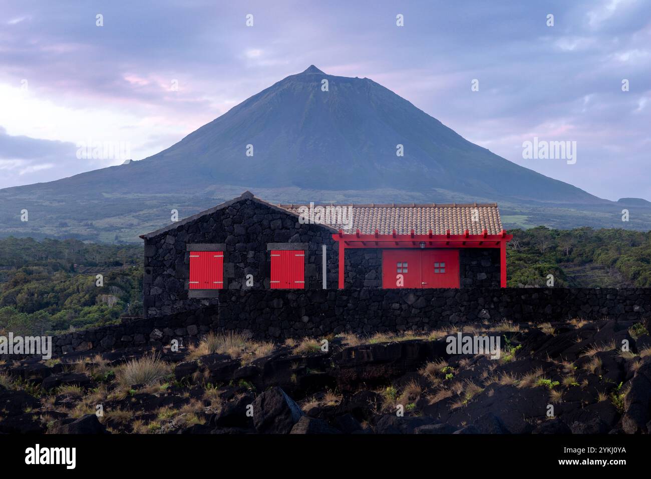 Cabrito auf der Insel Pico auf den Azoren hat einen Badebereich aus schwarzer Lava mit traditionellen Lavasteinhäusern mit Blick auf den majestätischen Mount Pico. Stockfoto