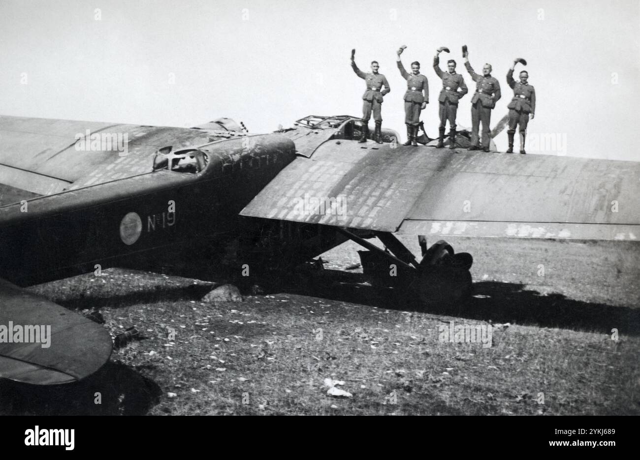 Ein zerstörter französischer Leichtbomber Amiot 143 mit jubelnden deutschen Soldaten stand während der Schlacht von Frankreich, ca. Juni 1940 auf dem Flügel. Stockfoto