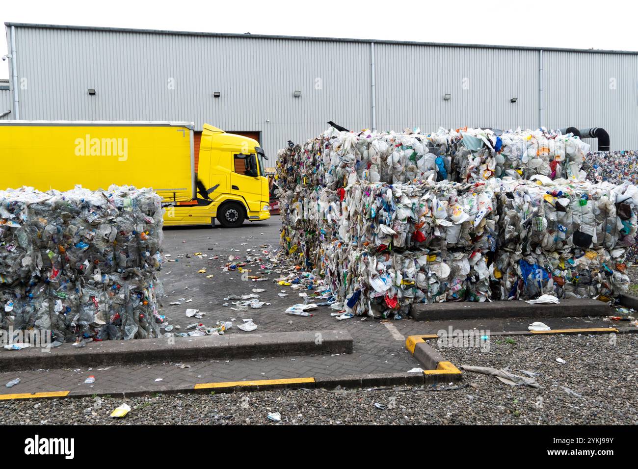 Gebrauchte Kunststoffmilchflaschen und -Kartons, die in Stapelballen gebündelt und für das Recycling in einer Recyclinganlage für industrielle Kunststoffabfälle bereit sind Stockfoto