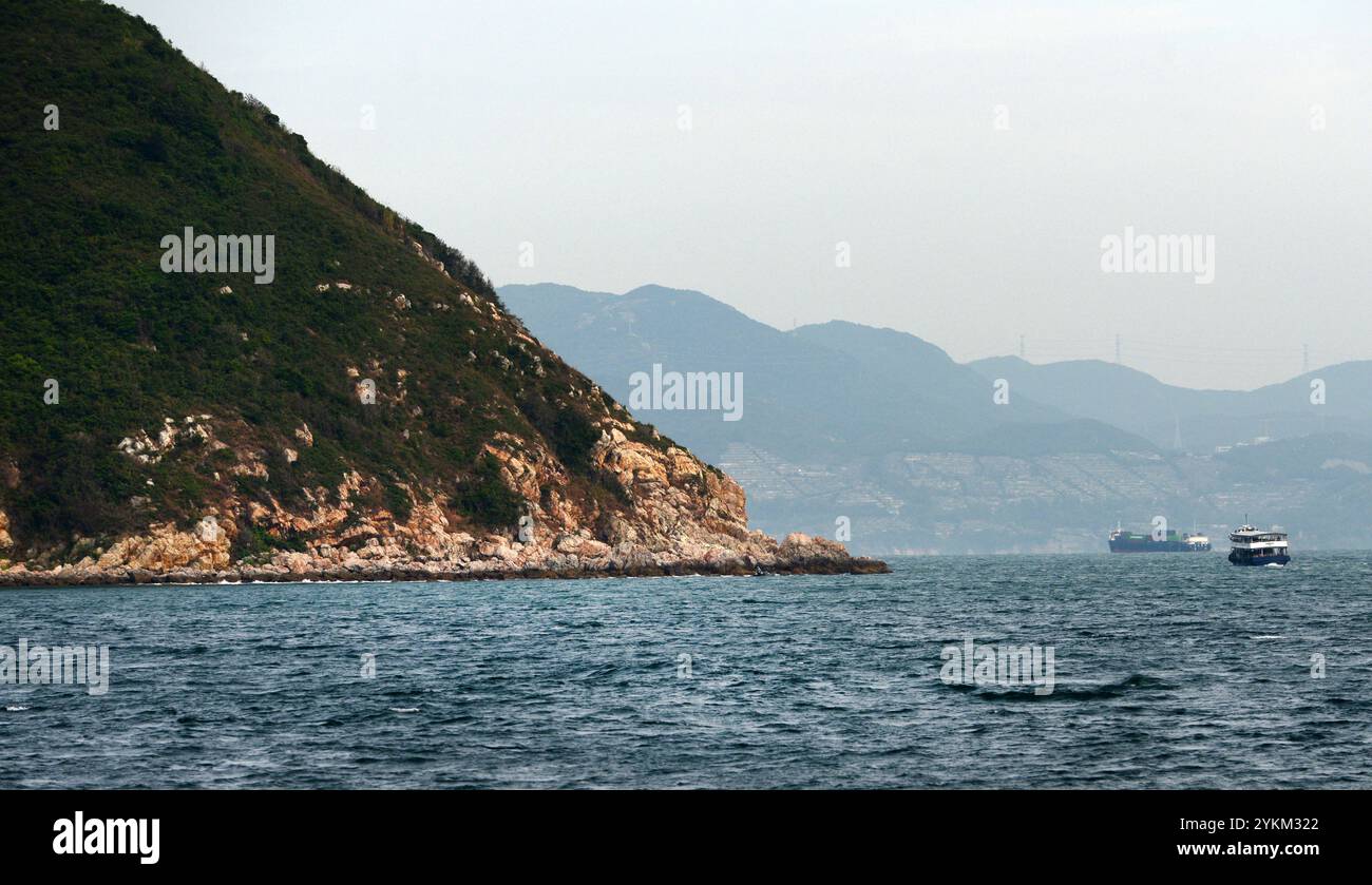 Felsige Landschaften im Plover Cove Country Park mit Yantian District in Shenzhen im Hintergrund. Stockfoto