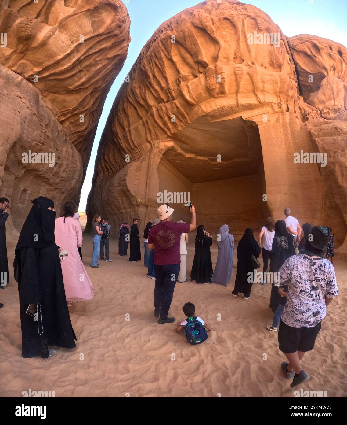 Gemischte Tourgruppe, die die antike nabatäische Siedlung Jabar Ithlib, archäologische Stätte Hegra (al-Hijr / Madā ͐ in Ṣāliḥ), in der Wüste nahe Al besichtigt Stockfoto
