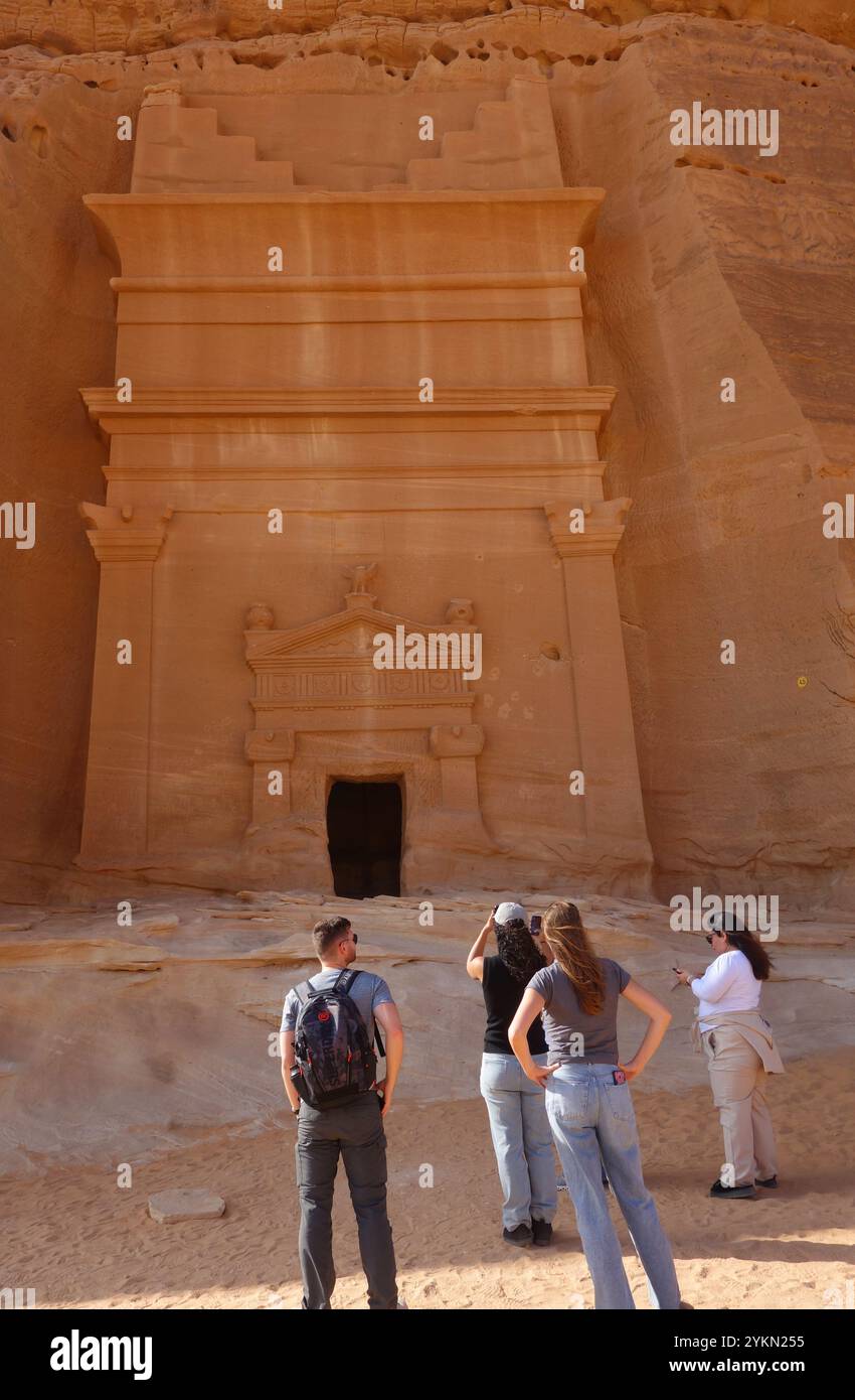 Touristen besichtigen Grab 45 in Jabal AlBanat (Qasr AlBint), Hegra Archäologische Stätte (al-Hijr / Madā ͐ in Ṣāliḥ), in der Wüste nahe Al Ula, Saudi-Arabien Stockfoto