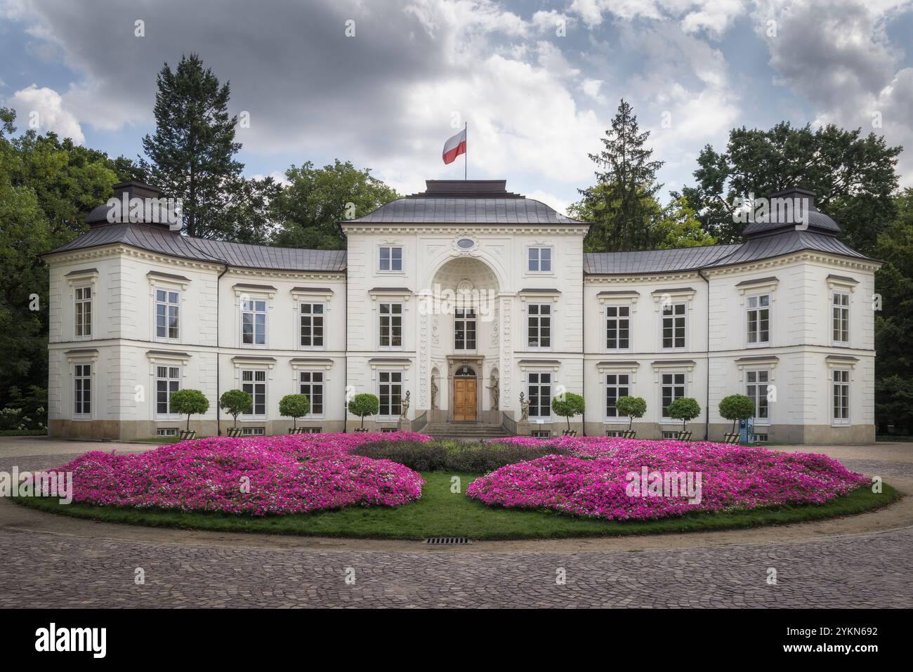 Der Mylewicki-Palast steht anmutig, geschmückt mit leuchtenden Blumen, die die Schönheit der Natur zeigen, in Warschau, Polen Stockfoto