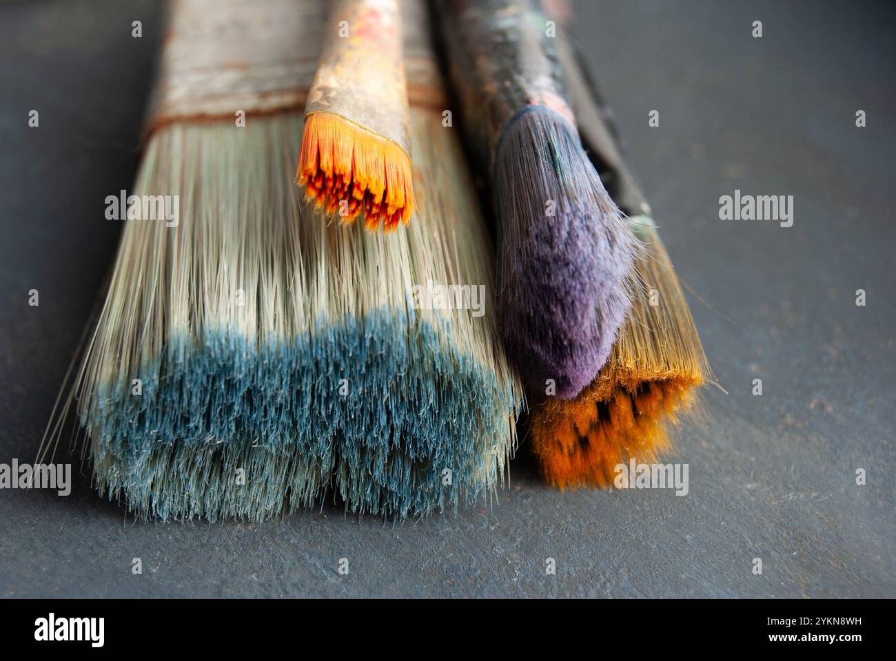 Künstlerische Werkzeuge, die auf einem farbenfrohen, strukturierten Hintergrund angeordnet sind, sind perfekt, um Kreativität zu zeigen. Stockfoto