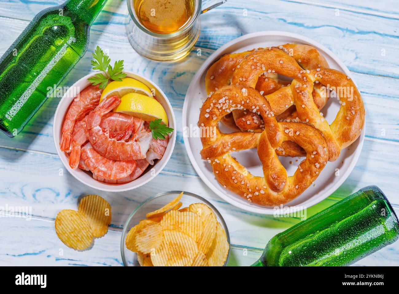 Ein lebhaftes Foto mit einem Glas Bier, umgeben von verschiedenen Snacks und Fast Food-Artikeln, schafft eine lustige und appetitliche Szene Stockfoto