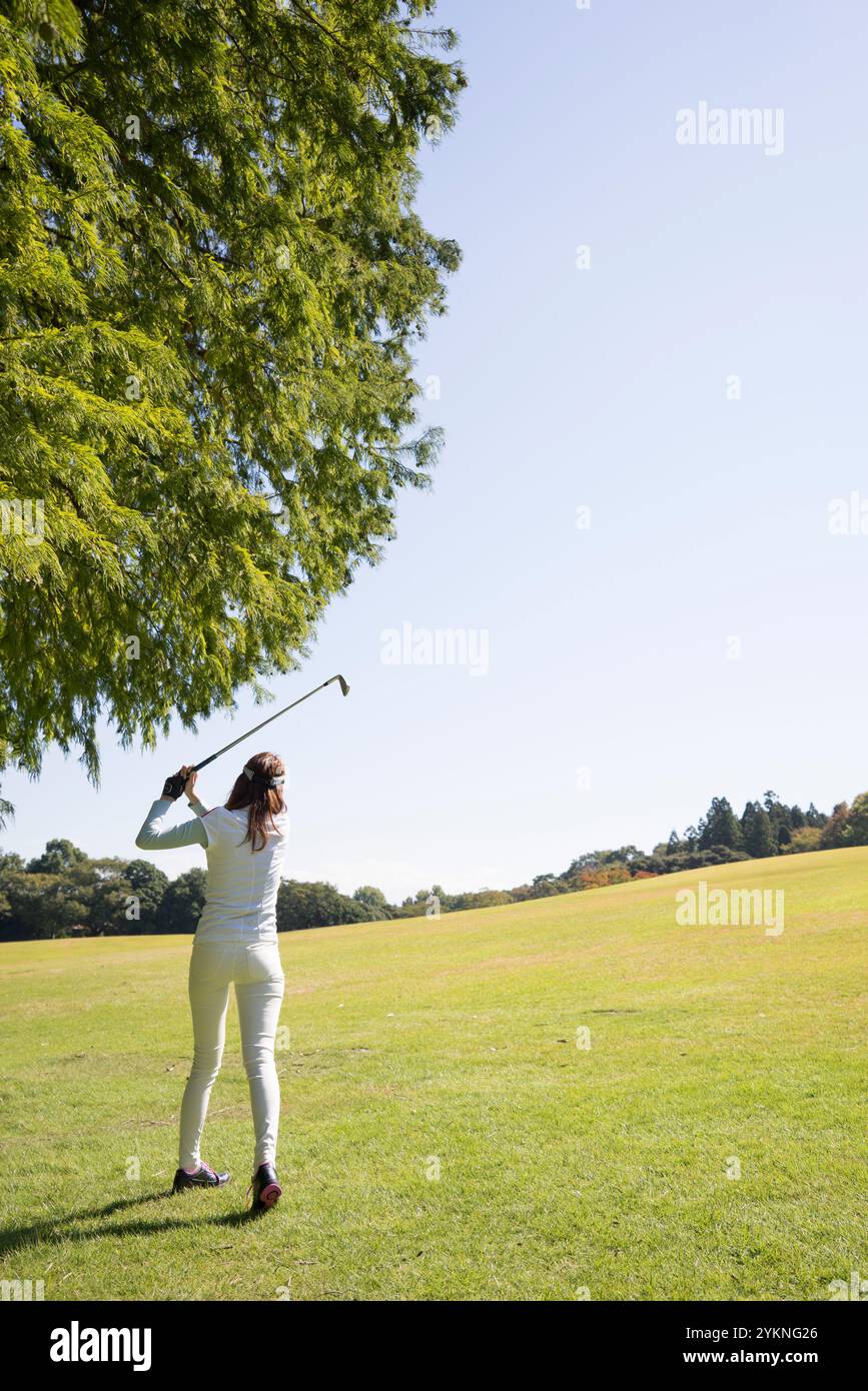 Eine Frau in ihren 20s, die Golf spielt Stockfoto