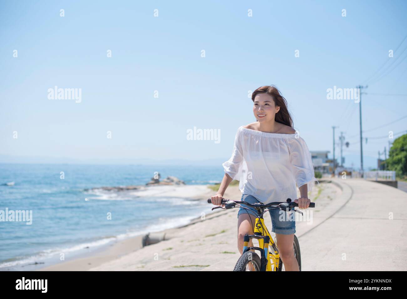 Frau radelt auf der Seebank Stockfoto