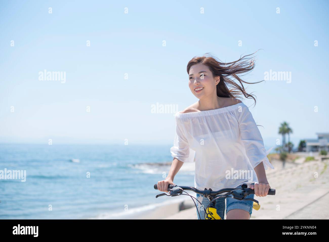 Frau radelt auf der Seebank Stockfoto