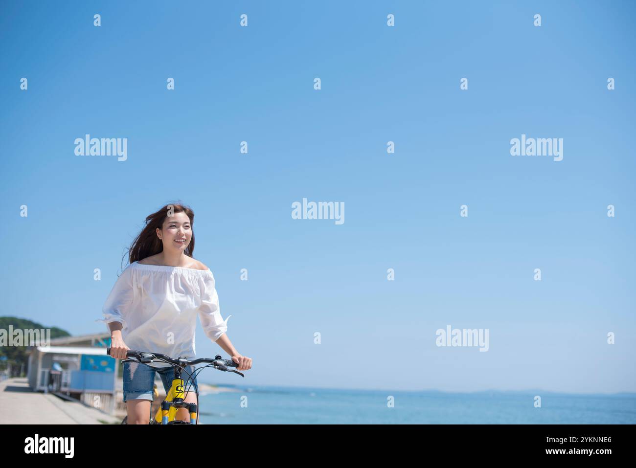 Frau radelt auf der Seebank Stockfoto