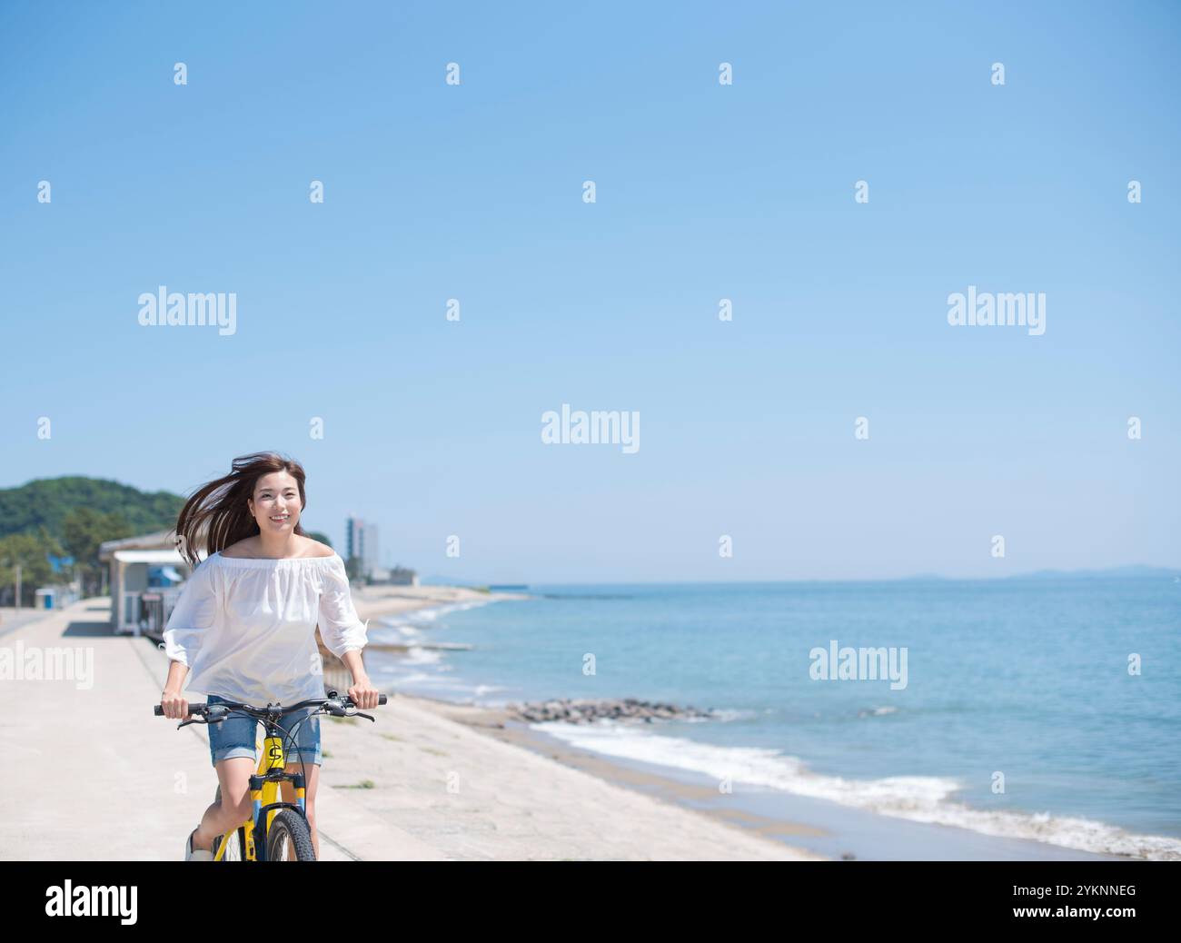 Frau radelt auf der Seebank Stockfoto