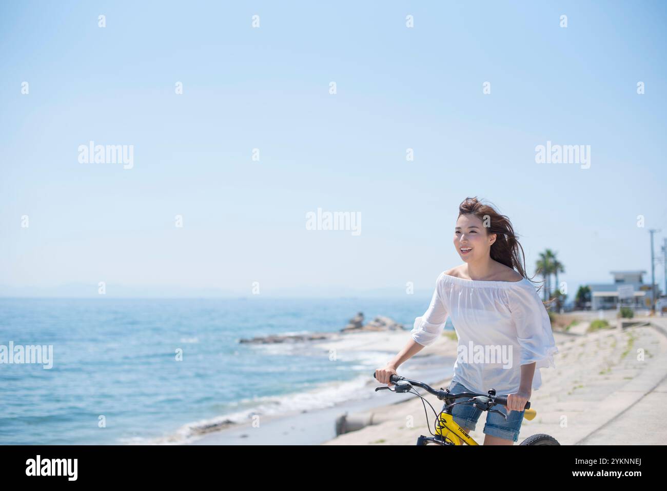 Frau radelt auf der Seebank Stockfoto