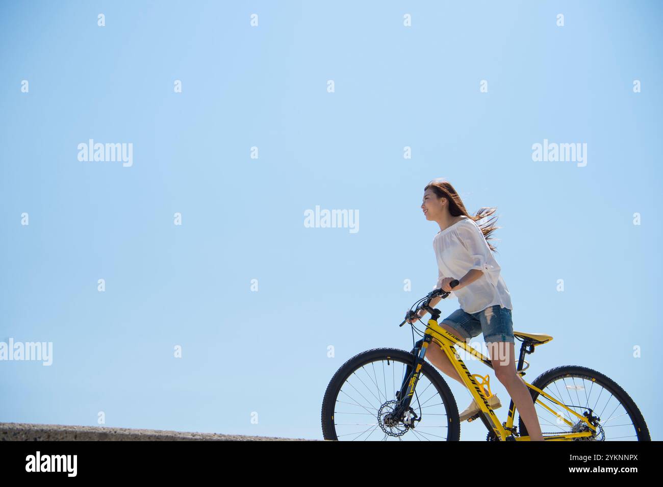 Frau radelt auf der Seebank Stockfoto