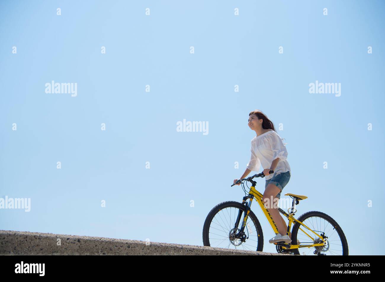 Frau radelt auf der Seebank Stockfoto