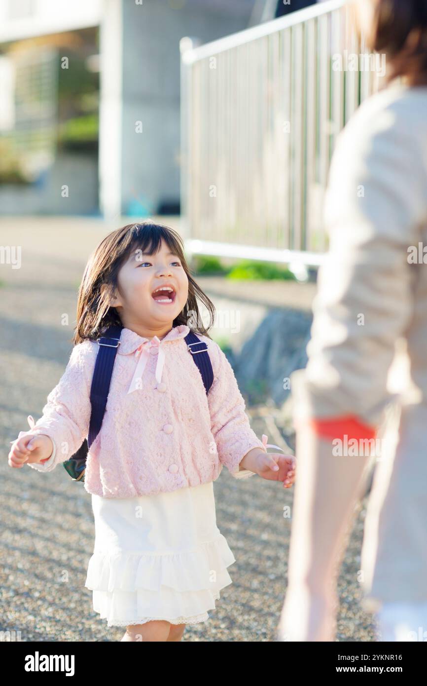 Kindergartenmädchen rennt auf die Mutter zu Stockfoto