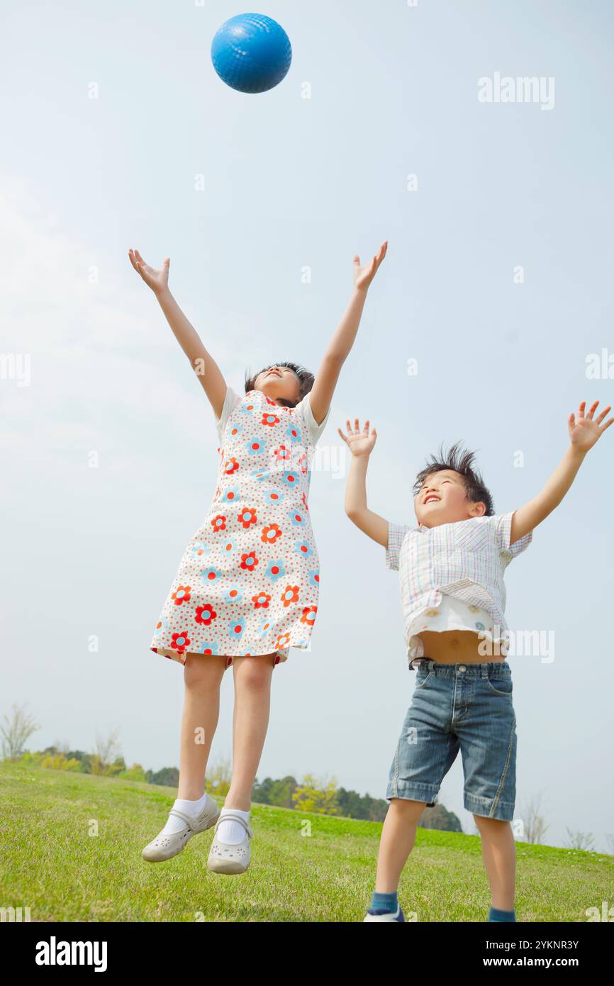 Schwester und Bruder spielen mit Ball Stockfoto
