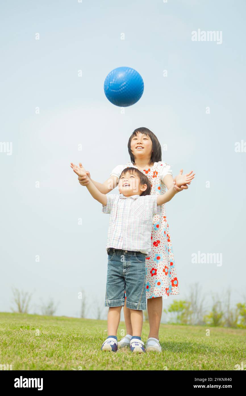 Schwester und Bruder spielen mit Ball Stockfoto
