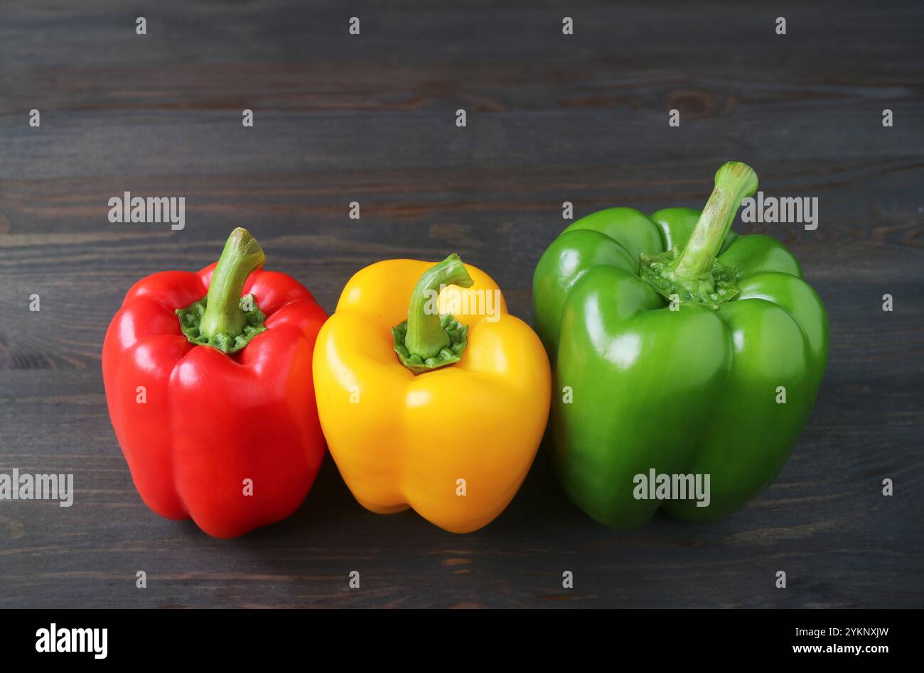 Lebendige Tricolor-Paprika auf Holzhintergrund Stockfoto
