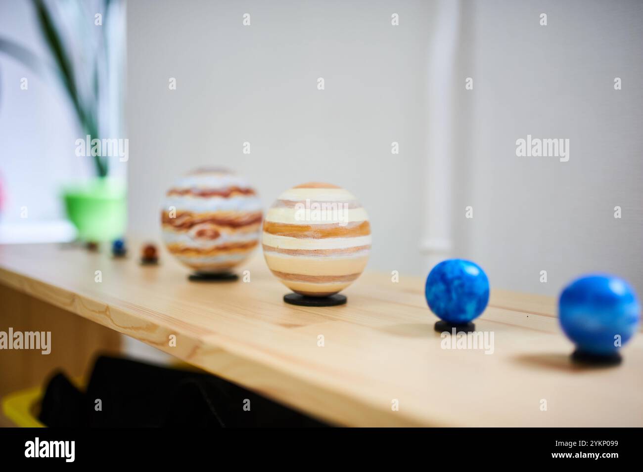 Montessori Solarsystem Modell auf einem Holzregal. Bemalte Planetenkugeln, die Planeten darstellen, angeordnet in Größe und Farbverlauf in einer Vorschule Stockfoto