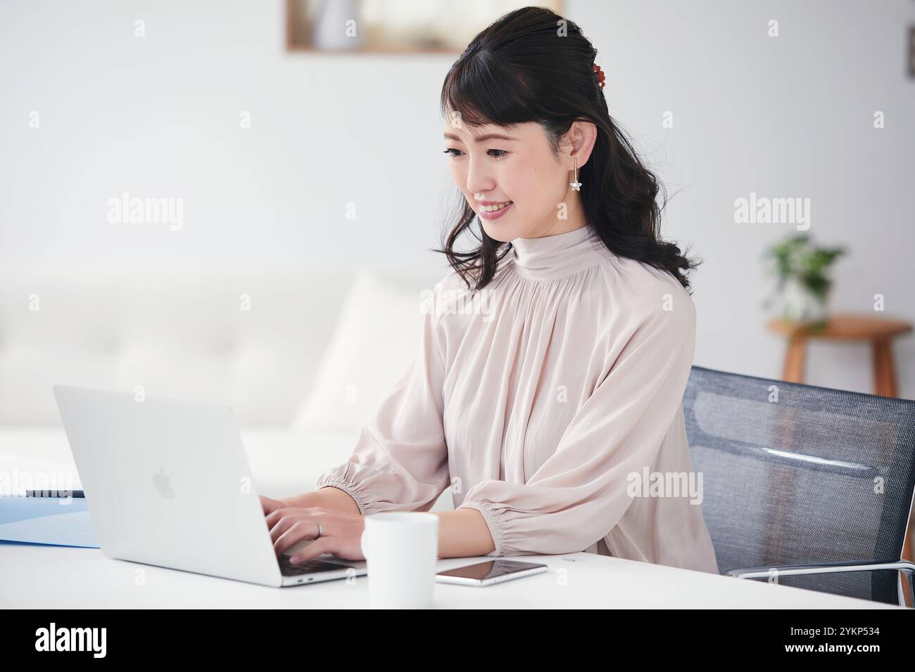Frau, die ein Online-Meeting hat, während sie sich einen Computer ansieht Stockfoto