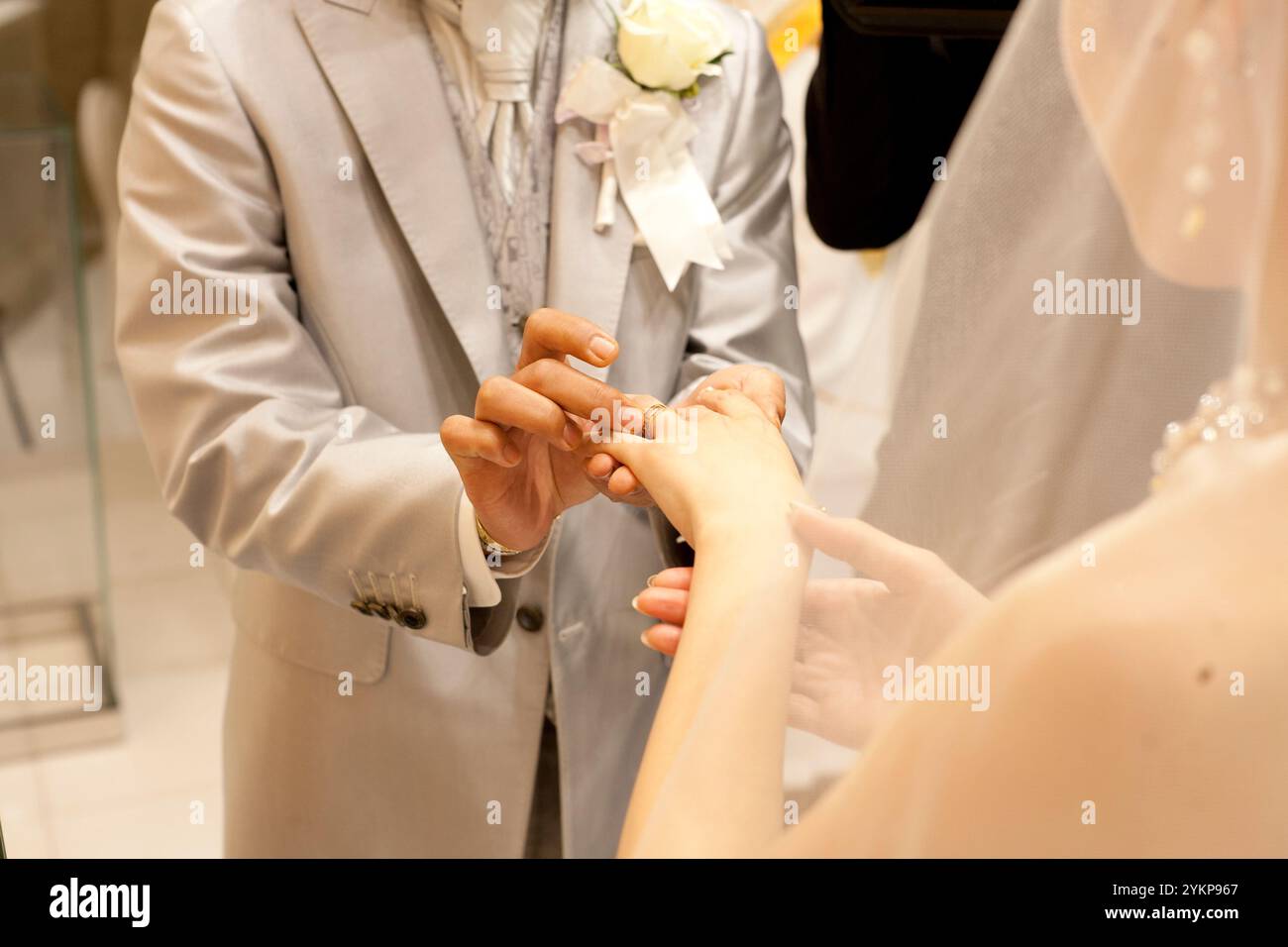 Braut und Bräutigam tauschen bei einer kirchlichen Hochzeit Ringe aus Stockfoto