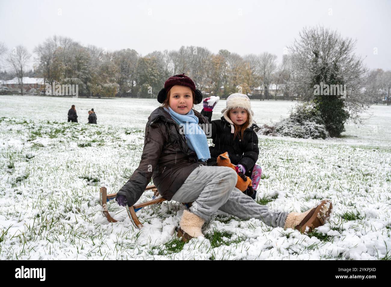 Die jungen Oxford-Schwestern (l-r) Scarlett und Ngaio waren begeistert, aufzuwachen und den Boden in einem frühen Schneefall zu finden. Sie machten sich mit ihrer Mutter und einer Holzrodelbahn auf den Weg nach South Park. Leider reichte die Schneedecke nicht ganz für den Holzschlitten aus und bald bat der kleine Ngaio nach Hause zu gehen, da der Spaß kalt wurde. Stockfoto