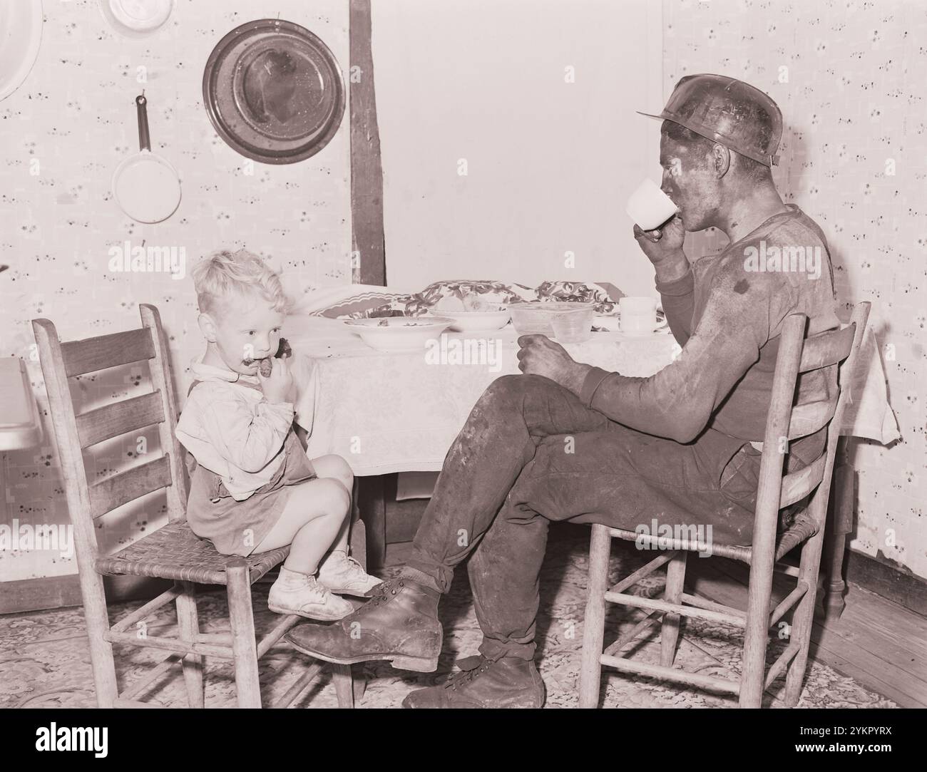 Vintage-Foto von amerikanischen Bergleuten. Rufus Sergent, Bergmann, und sein Sohn haben nach der Arbeit etwas zu essen. P V & K Coal Company, Clover Gap Mine, Lejunior, Harlan County, Kentucky. USA. September 1946 Stockfoto