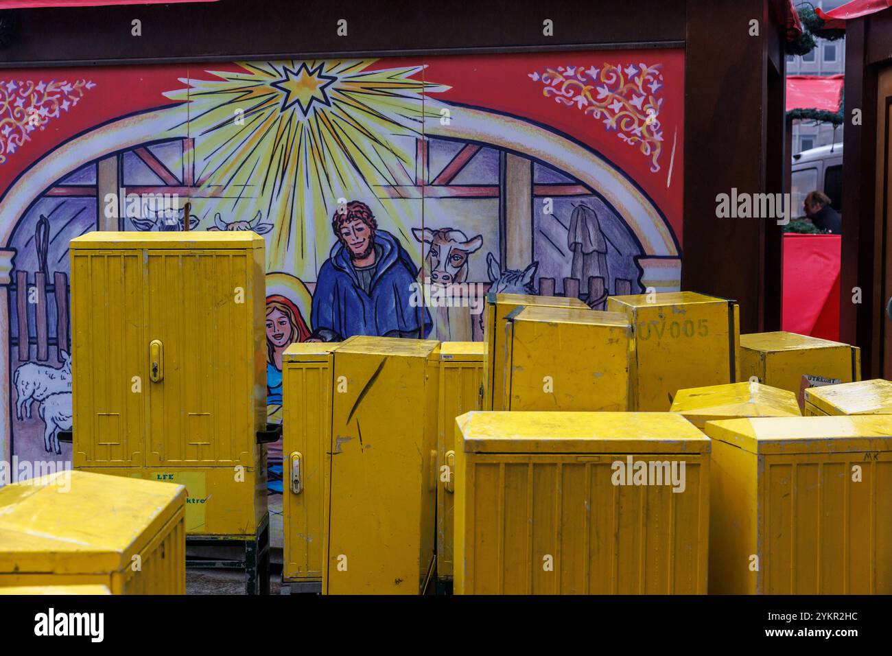 Elektroschränke stehen vor einem Stand mit einem Motiv des Stalls von Bethlehem auf dem Weihnachtsmarkt am Roncalliplatz am Dom, Colog Stockfoto