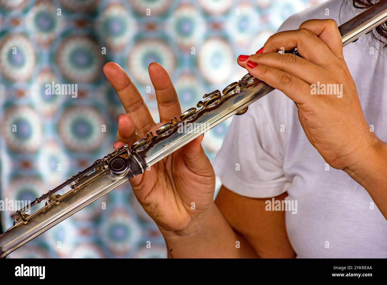 Details der Hände einer Querflöte spielenden Frau während einer musikalischen Aufführung Stockfoto