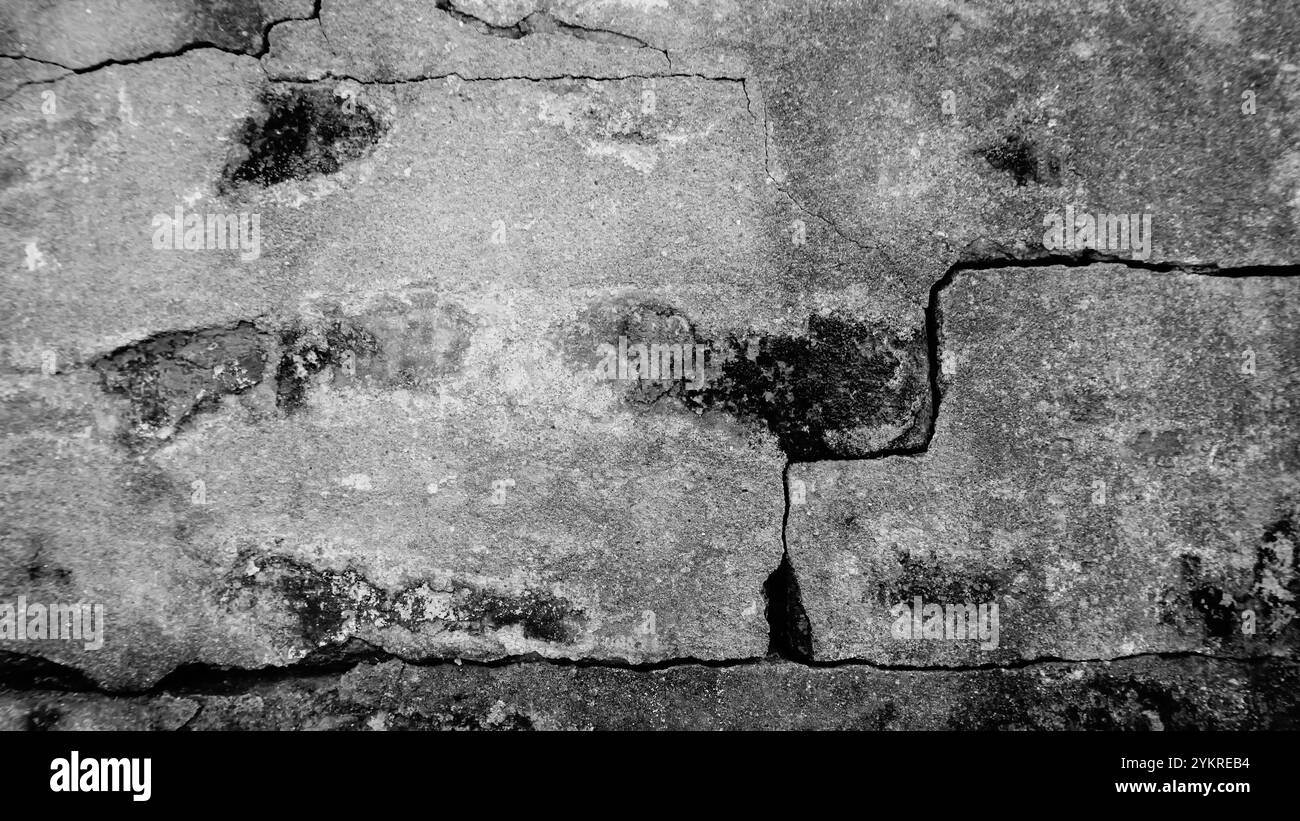 Alterungsspuren, die abstrakte Bilder an einer alten Wand erzeugen, gebrochener Putz, der mit langer Zeit veraltert wurde. Schwarzweißbild des Alterns, dargestellt auf einer alten Wand. Stockfoto