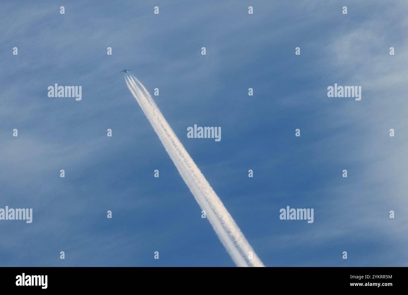Passagierjets, die in großer Höhe fliegen, hinterlassen Kondensstreifen aus Eiskristallen, während heiße Abgase auf kalte, trockene Luft in der oberen Atmosphäre treffen. Stockfoto