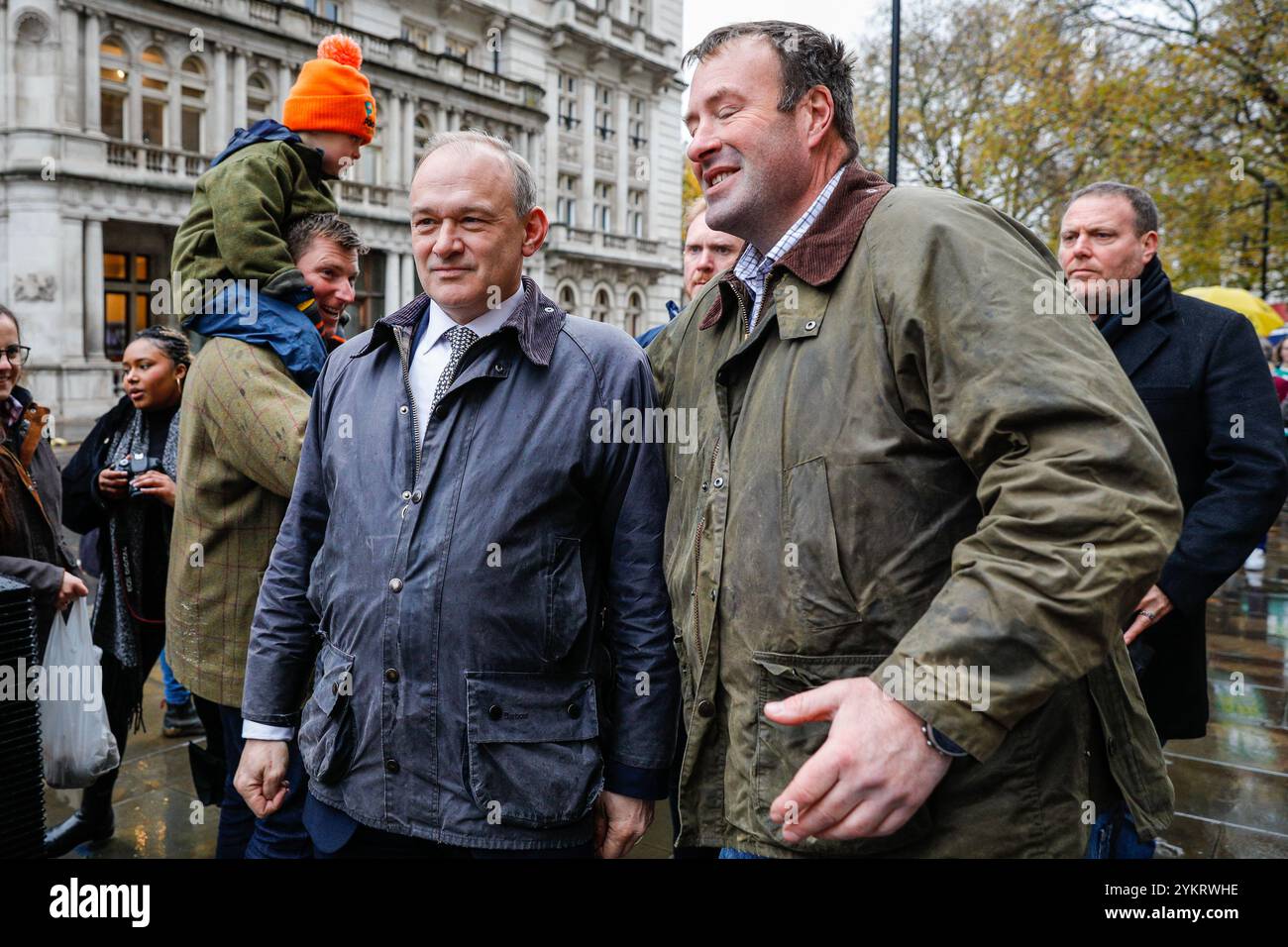 London, Großbritannien. November 2024. Sir Ed Davey, Führer der Liberaldemokraten, geht mit seinem Team und Tim Farron auf die Kundgebung zu. Eine große Gruppe landwirtschaftlicher Kinder auf Spielzeugtraktoren führt den Weg zu einer Prozession um den Parlamentsplatz. Bauern, ihre Familien und Unterstützer protestieren im Zentrum Londons gegen Pläne zur Einführung der Erbschaftssteuer für Landwirte. Quelle: Imageplotter/Alamy Live News Stockfoto