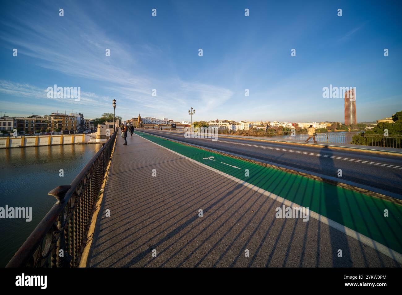 Sevilla, Spanien, 28. Januar 2021, Weitwinkelansicht der Triana-Brücke über den Guadalquivir-Fluss in Sevilla, Spanien. Torre Sevilla im Hintergrund unter einem Klartext Stockfoto