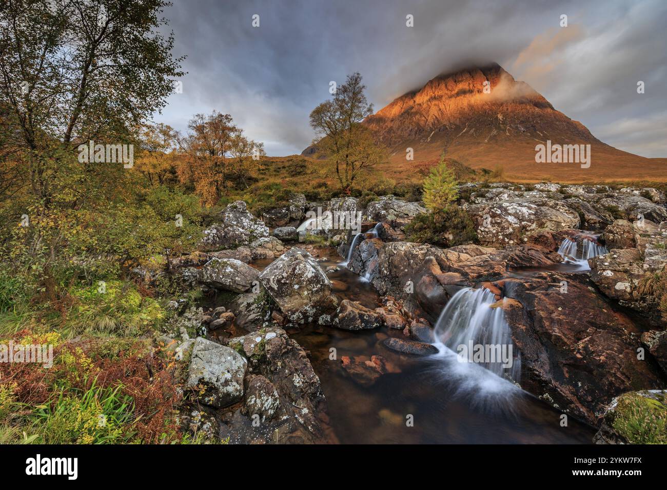 Wilder Fluss, Wasserfall, Herbstfarben, Morgenlicht, Berglandschaft, bewölkte Stimmung, Buachaille Etive Mor, Glencoe, Scottish Highlands, Schottland, G Stockfoto