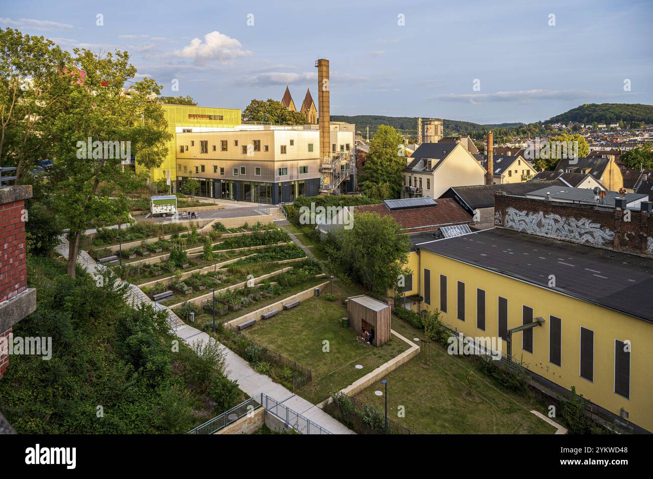 Stadtlandschaft mit modernen Gebäuden, Gärten und Graffiti, umgeben von üppigem Grün unter sonnigem Himmel, Bob-Campus in Wuppertal Oberbarmen Stockfoto