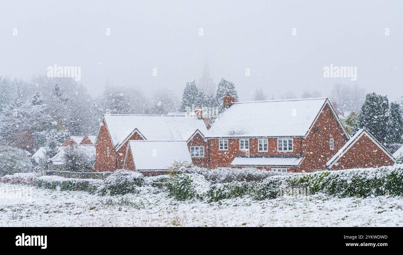 Malerische Szene mit roten Backsteinhäusern in einem malerischen Dorf während eines Schneesturms Stockfoto