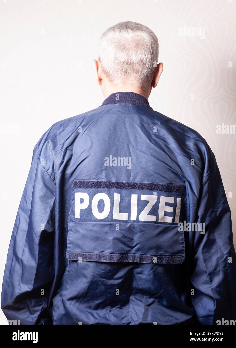 Mann in einer Nylonjacke mit der Aufschrift in der deutschen POLIZEI Stockfoto