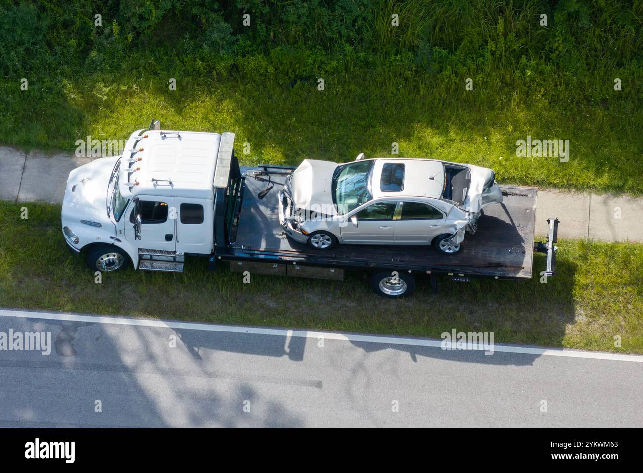 Autounfallstelle mit einem Abschleppwagen, der zerstörtes Fahrzeug auf der amerikanischen Straße beladen hat. Notfallpersonal, das auf einen Unfall in Florida, USA reagiert. Stockfoto